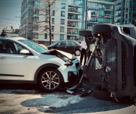 Zwei PKWs, die in einen Unfall verwickelt sind. Ein Auto liegt auf der Seite. Beide Autos haben einen Schaden. Die Straße ist voller Scherben. EKR - Engelbrecht Krawiec Rechtsanwälte - Düsseldorf
